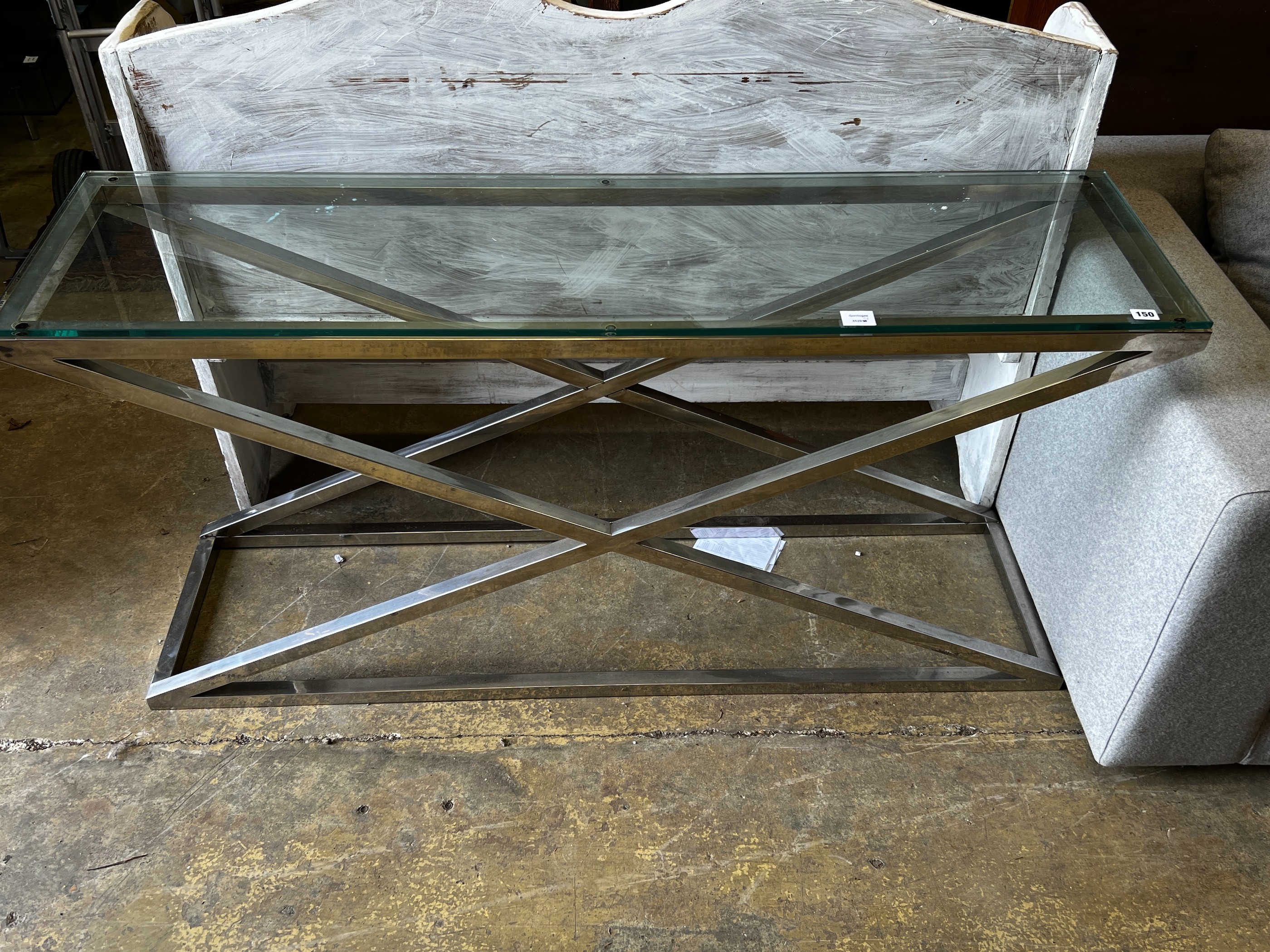 A contemporary rectangular glass top console table on X shaped frame, width 150cm, depth 40cm, height 74cm